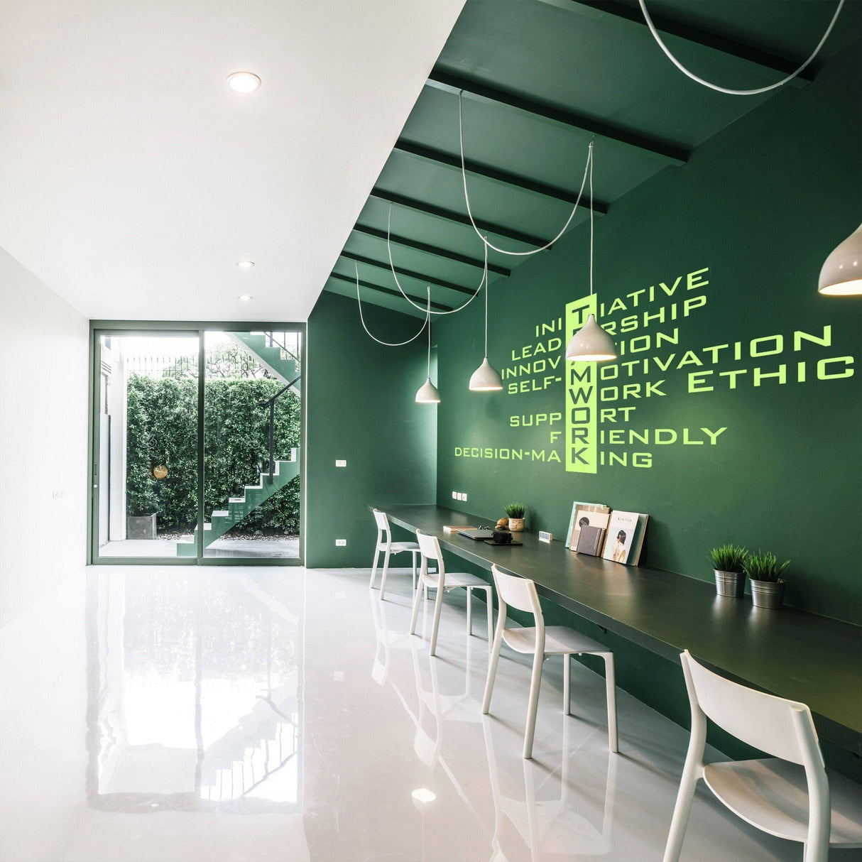 InspireX wall decal featuring motivational words in a modern office with green walls and sleek furniture.