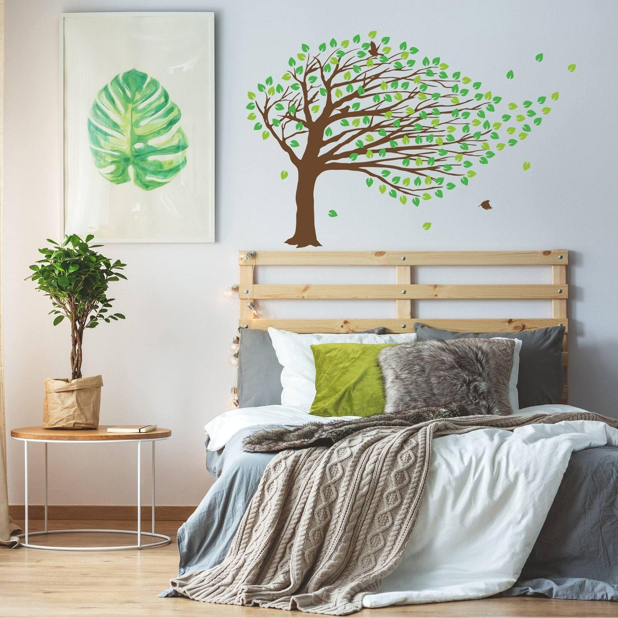 Decorative fantasy tree wall sticker in a cozy bedroom setting with green leaves and a modern design.