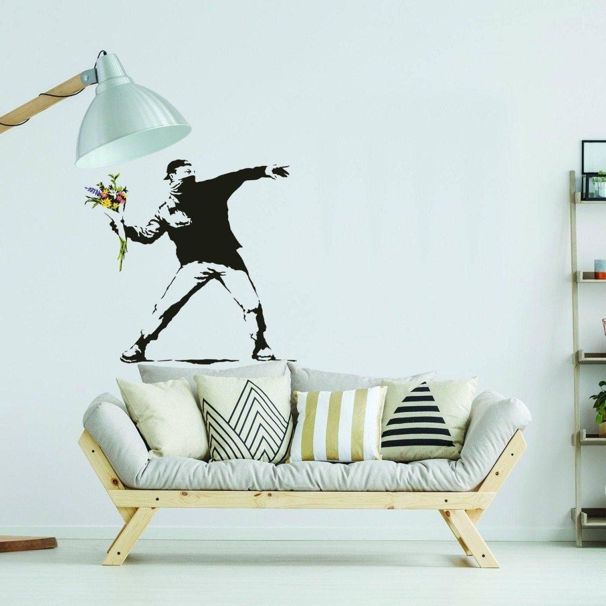 Vinyl wall decal of a boy throwing flowers, adding artistic flair to modern home decor with stylish sofa.
