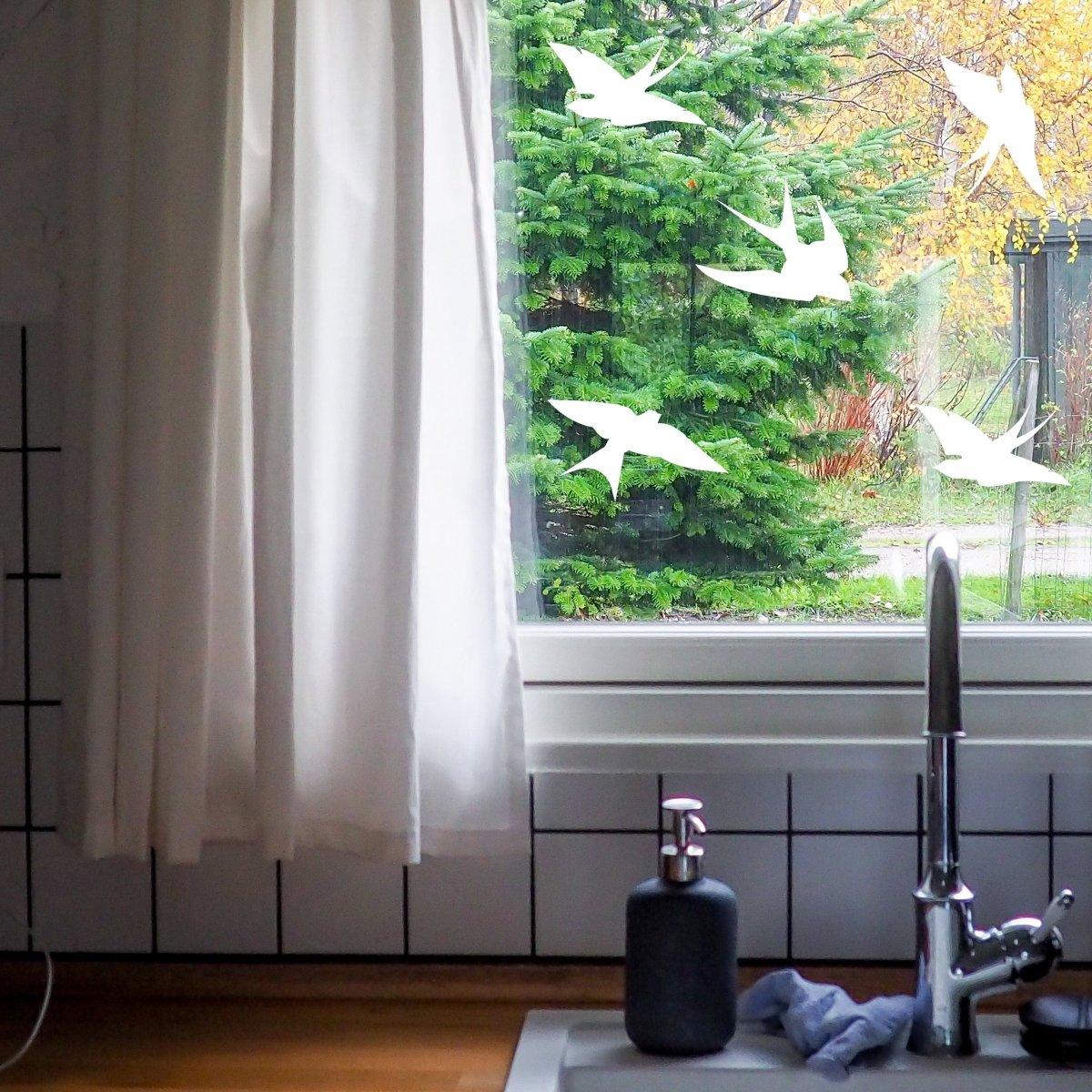 Window decal set with frosted bird silhouettes protecting against bird strikes, enhancing home aesthetics.