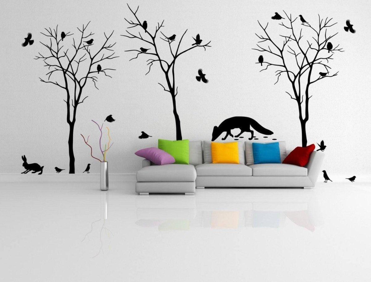Stylish living room featuring nature-inspired wall decals of trees, birds, and animals with colorful couch pillows.