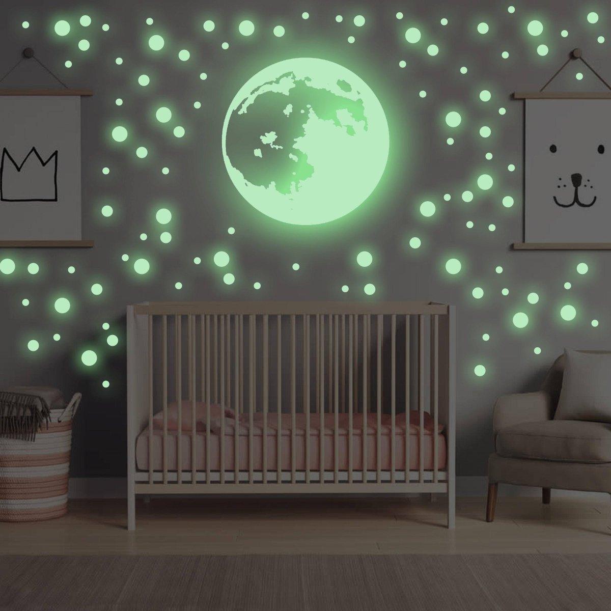 Glow in the dark moon and star wall stickers in a nursery creating a magical celestial atmosphere.