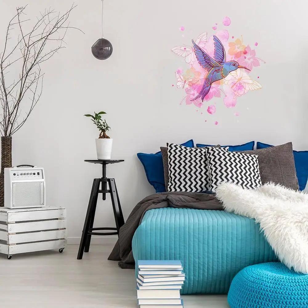 Colorful hummingbird wall vinyl sticker in a stylish bedroom decor with blue accents and plants.