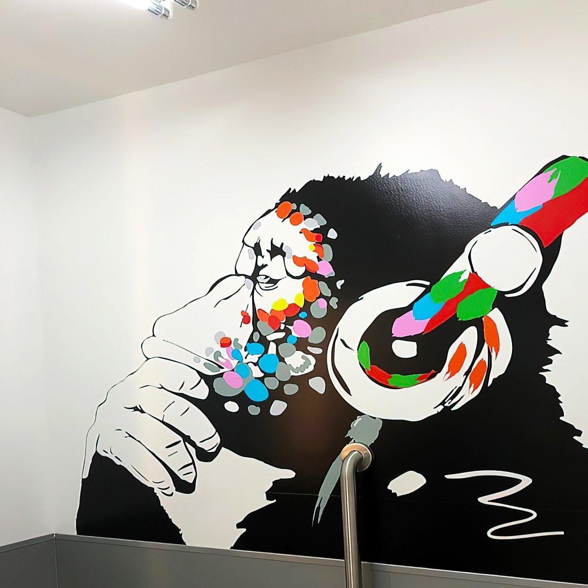 Contemplative monkey wall decal with colorful headphones, perfect for kids' room decoration or stylish office decor.