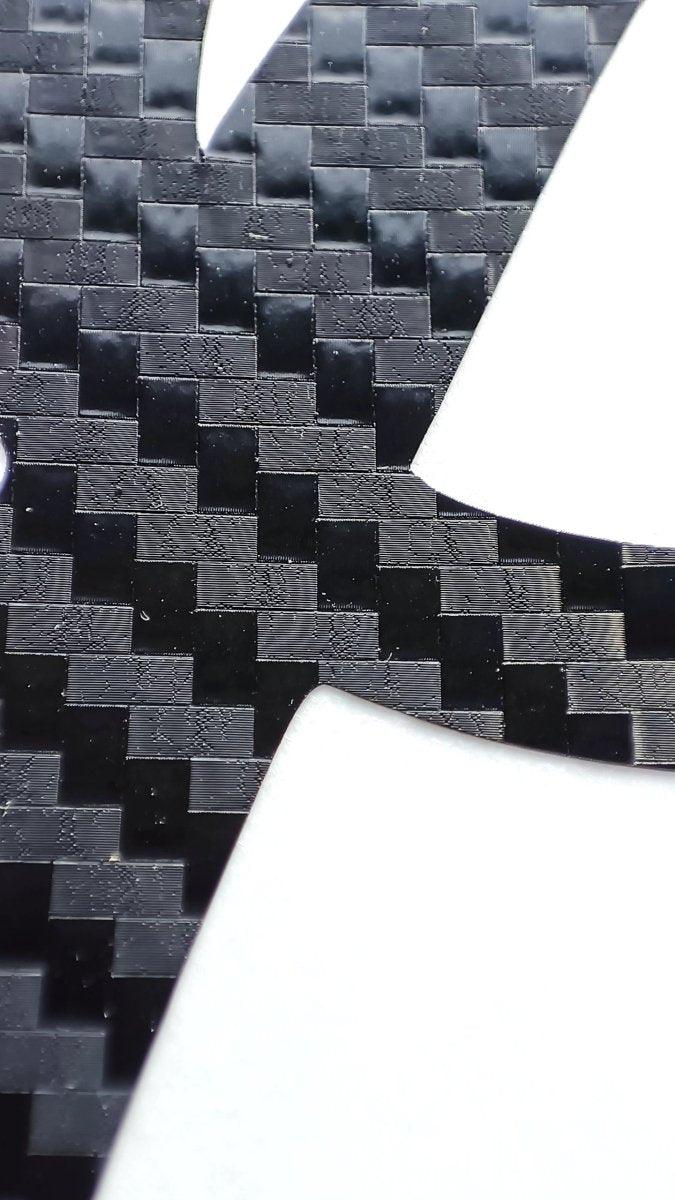 Close-up of personalized carbon fiber letter decal showcasing the textured pattern of durable vinyl.