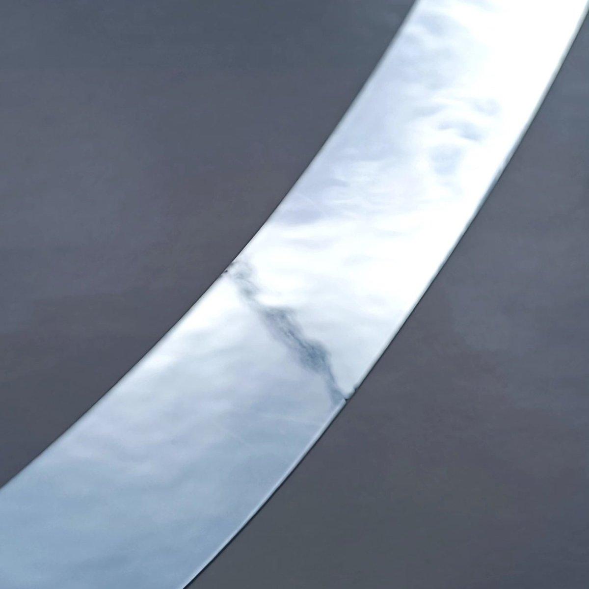 Close-up of personalized metallic name decal on a dark surface, showcasing its shiny finish and quality.