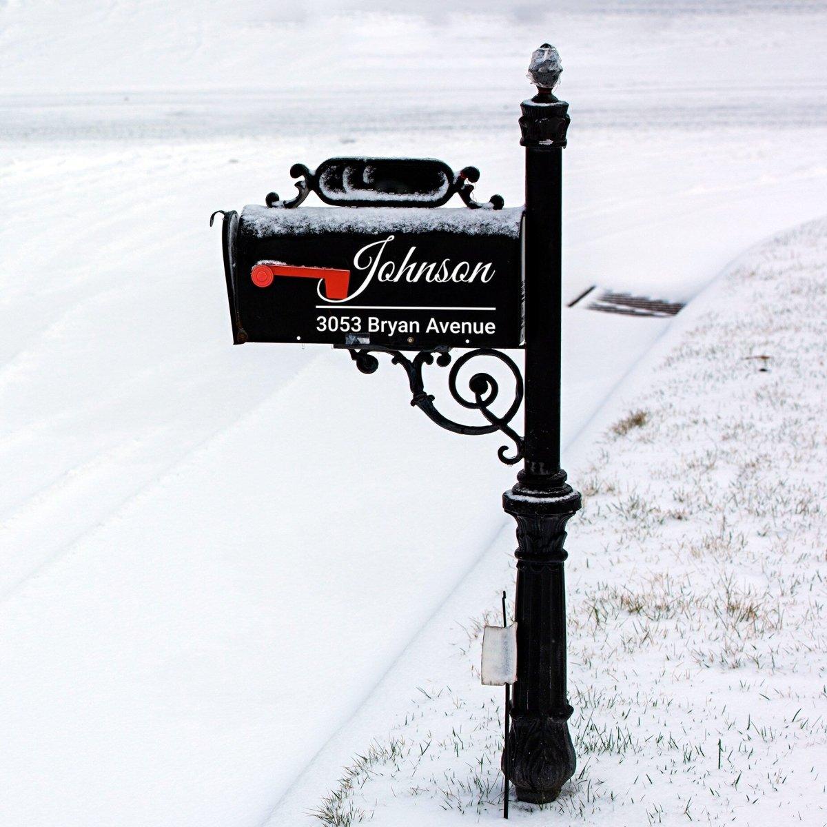 Personalized reflective mailbox decal on a black mailbox in snowy landscape, displaying name and address clearly.