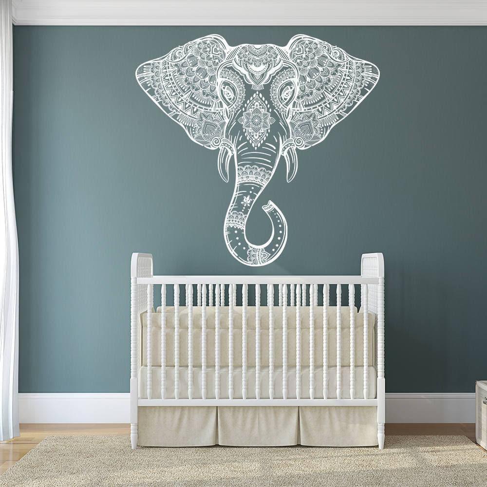 Whimsical elephant wall decal above a stylish crib, adding charm and elegance to a nursery decor.