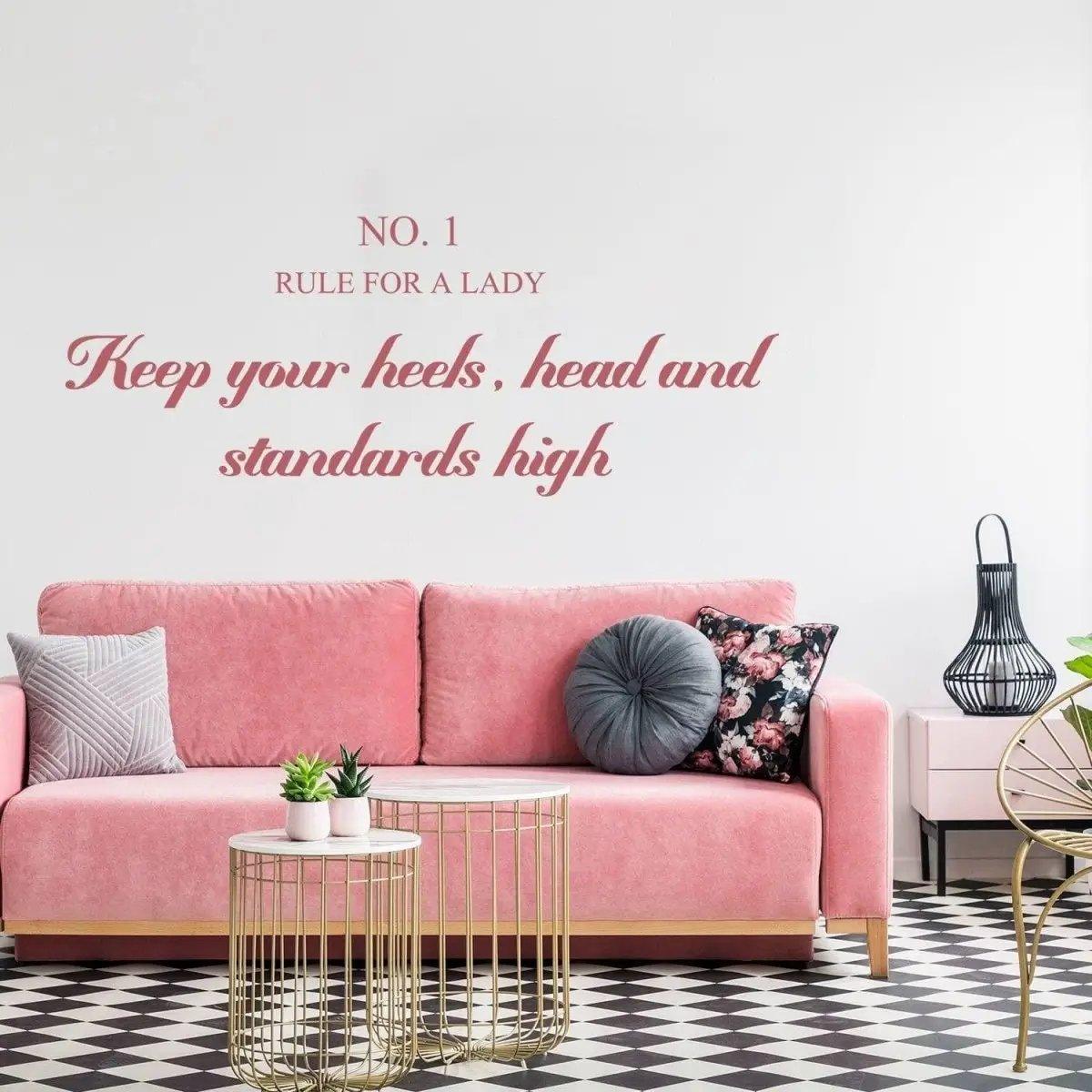 Chic etiquette wall sticker above a pink couch with 'Keep your heels, head and standards high' inspirational quote.