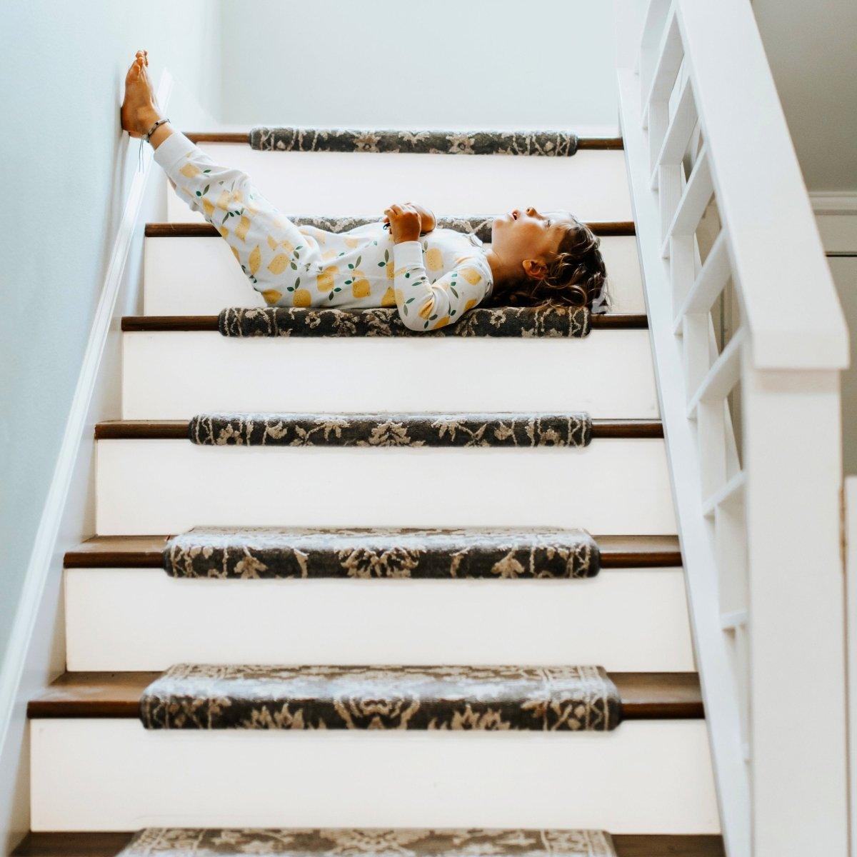 Child lounging on staircase with stylish rug pads, showcasing a cozy and playful home decor.