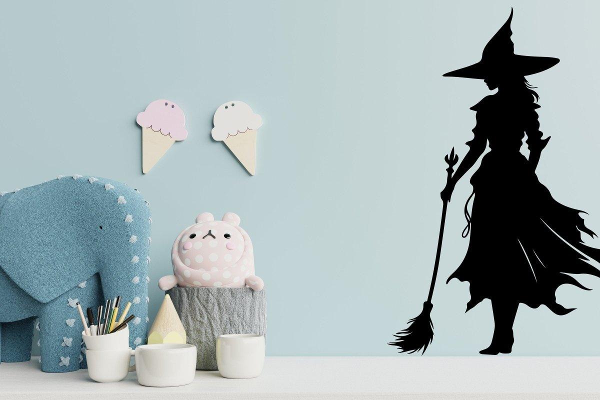 Witch silhouette decal on light blue wall, adding Halloween charm to a playful nursery setting.
