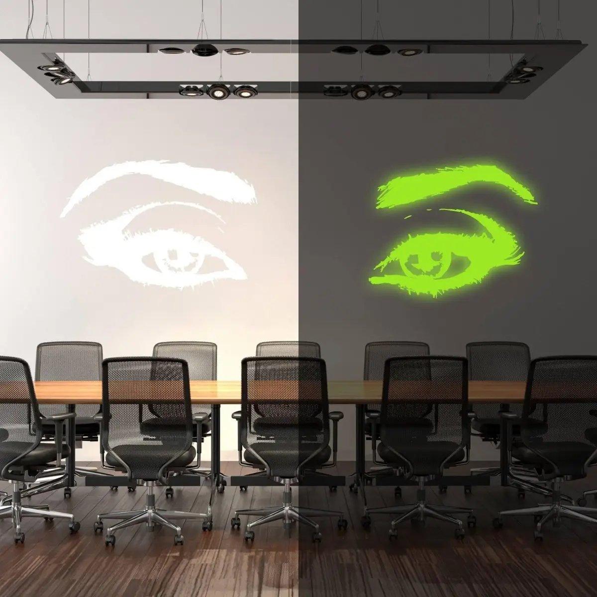 Glowing luminescent eye wall decal in a modern conference room, showcasing daytime and nighttime illumination effects.