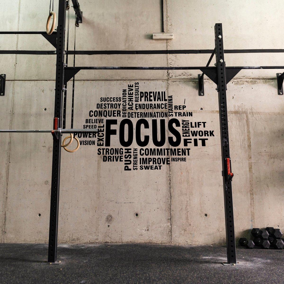 Inspirational fitness wall decal with motivational words like 'Focus,' 'Strength,' and 'Commitment' in a gym setting.