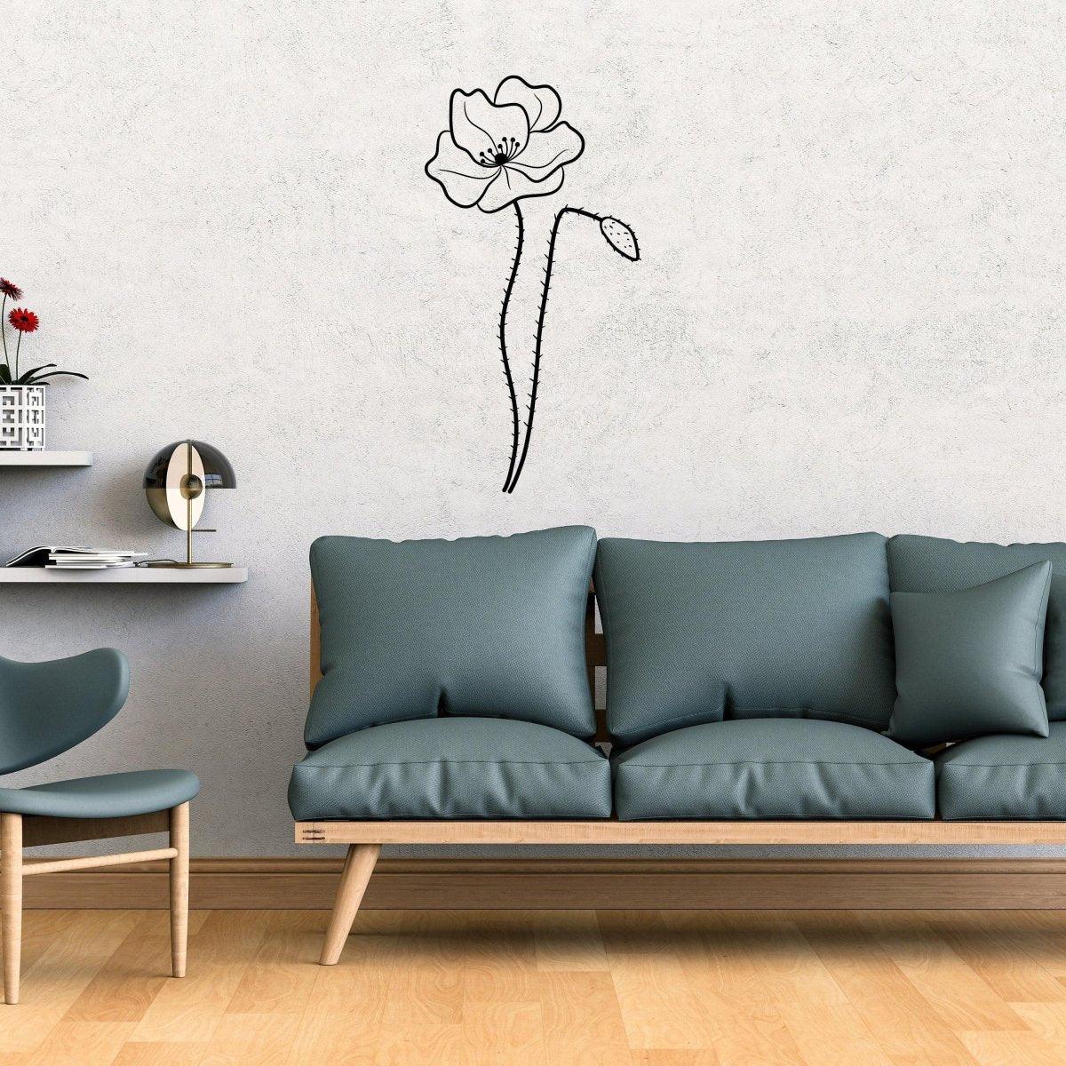 Delicate black floral wall decal sticker above a modern blue couch in a stylish living room setting.