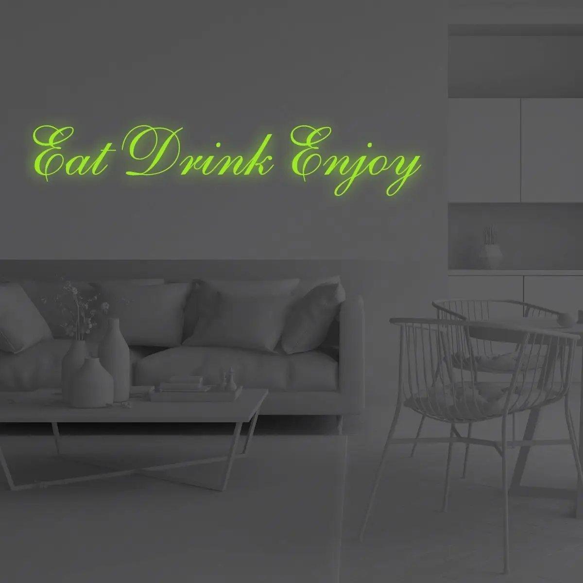 Illuminated 'Eat Drink Enjoy' vinyl decal glowing on a smooth wall in a modern kitchen setting.