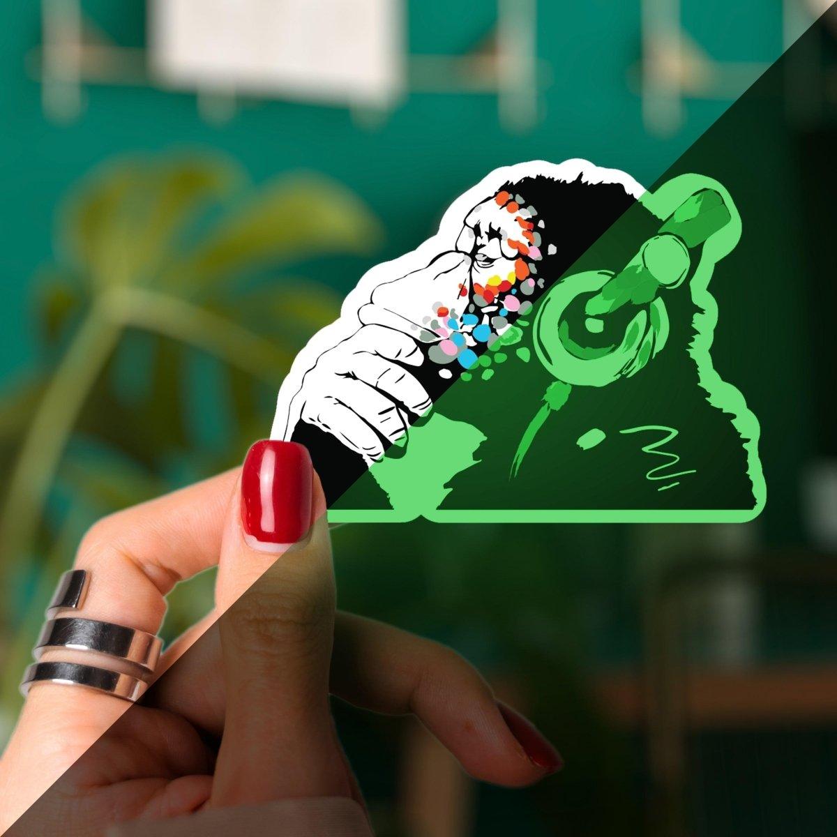 Glow in the dark monkey vinyl laptop decal featuring colorful headphones, perfect for fun surfaces.