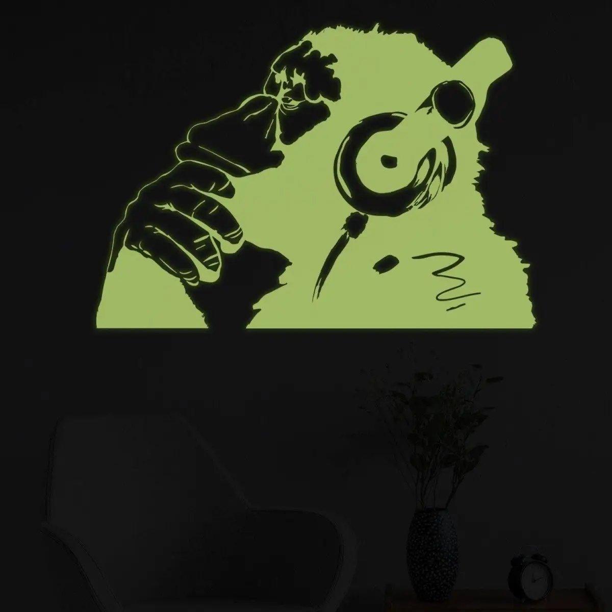 Glowing vinyl wall decal of a monkey with headphones, creating a vibrant luminescent effect in any room.