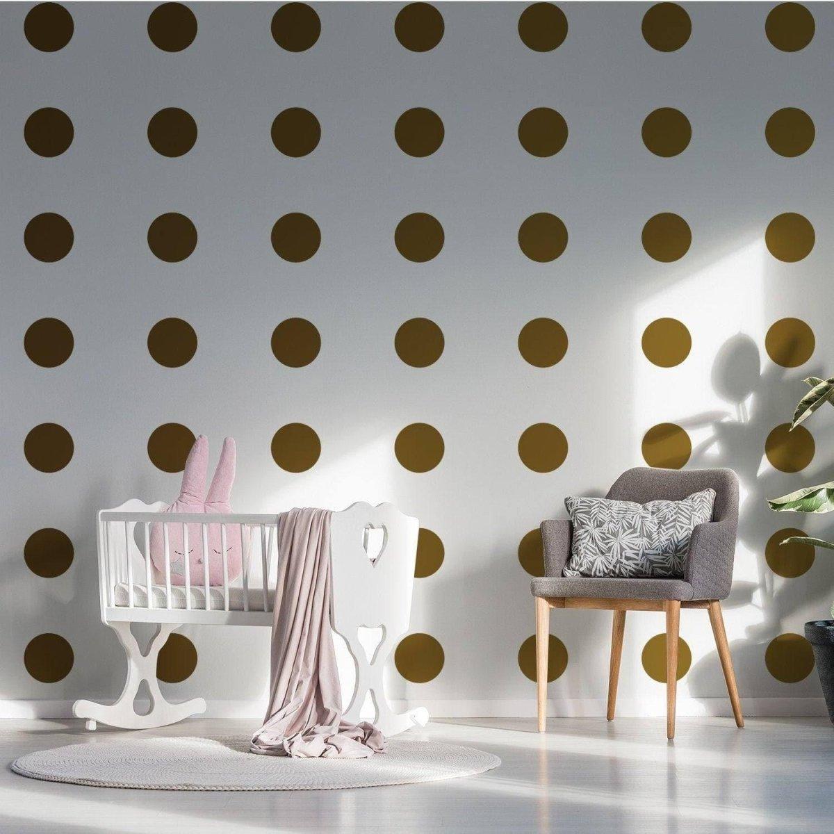 Gold circle wall decals in a nursery with white furniture and pink accents, adding a magical touch to the space.