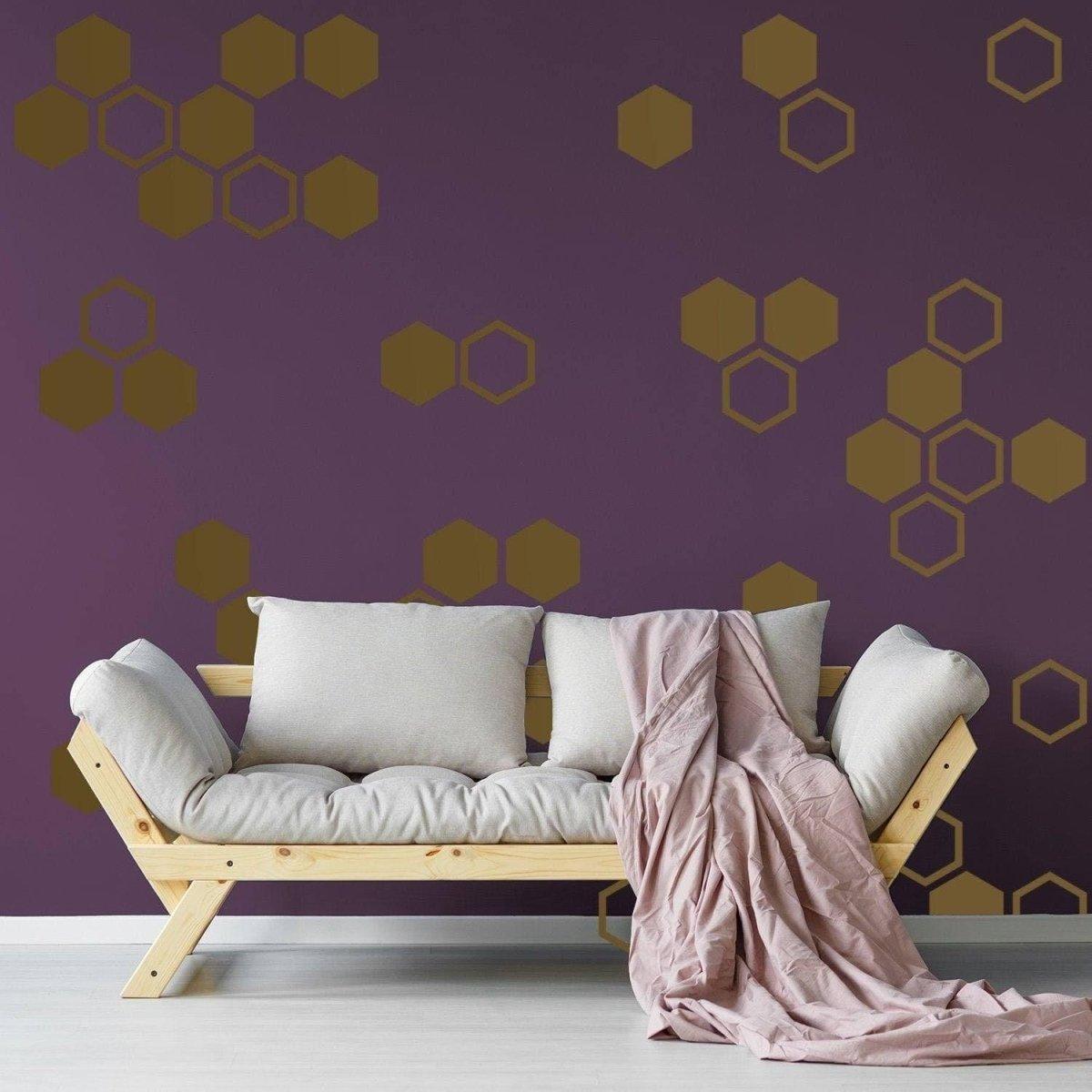 Hexagon wall decals in golden honeycomb design on a purple wall, enhancing living room aesthetics with elegance.