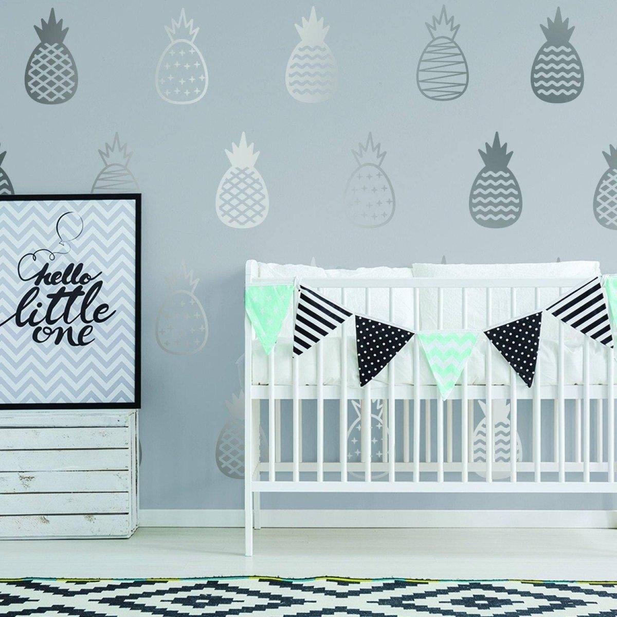 Chic vinyl wall decals featuring pineapples in a stylish nursery with a crib and decorative banner.