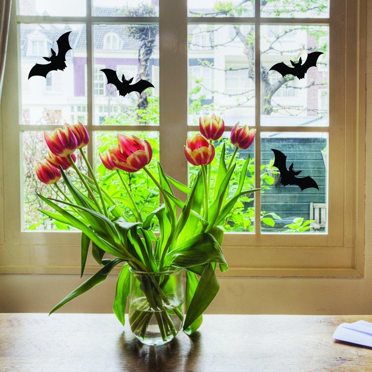 Window decorated with Halloween bat decals and tulips, adding spooky charm to the home.