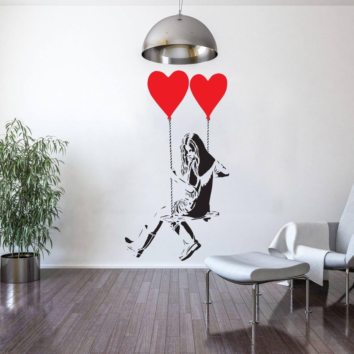 Vinyl heart balloon wall decal featuring a girl swinging with red heart balloons, perfect for creative space decor.
