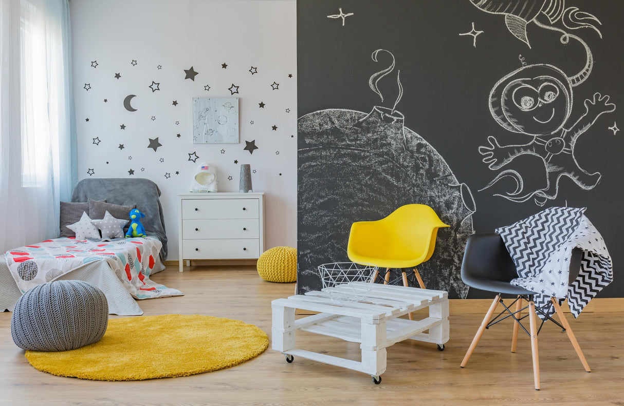Colorful kids' room with chalkboard wall, yellow chair, and playful decor featuring stars and moon.