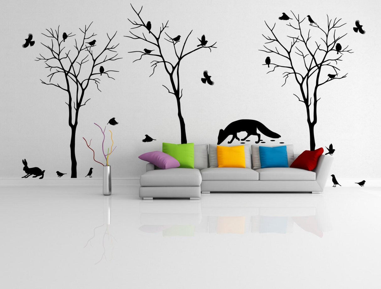 Stylish living room with colorful sofa and black tree wall decals featuring cute animals and birds.