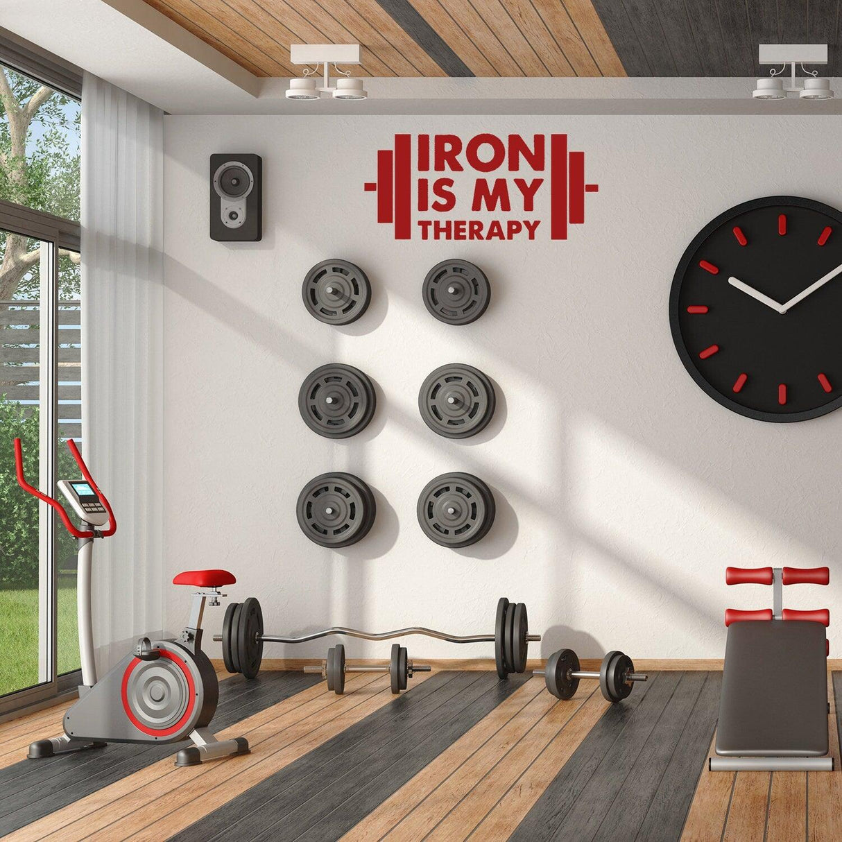 Fitness gym with motivational vinyl sticker, weights on wall, and exercise equipment in a bright, modern space.