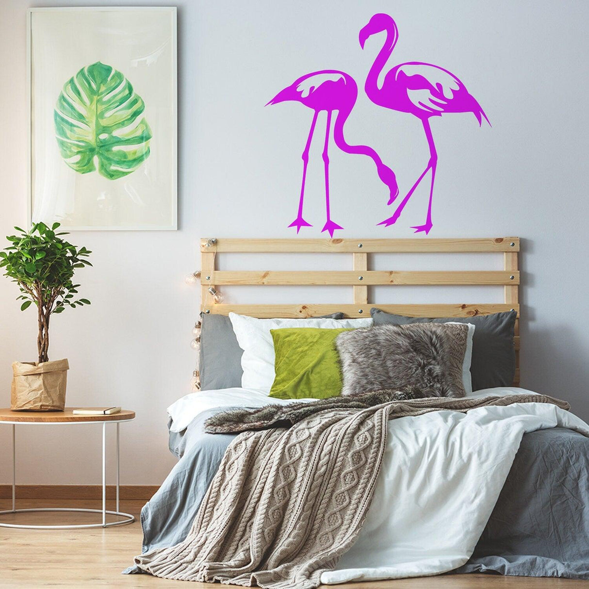 Bright pink flamingo wall decal in a cozy bedroom with tropical decor.