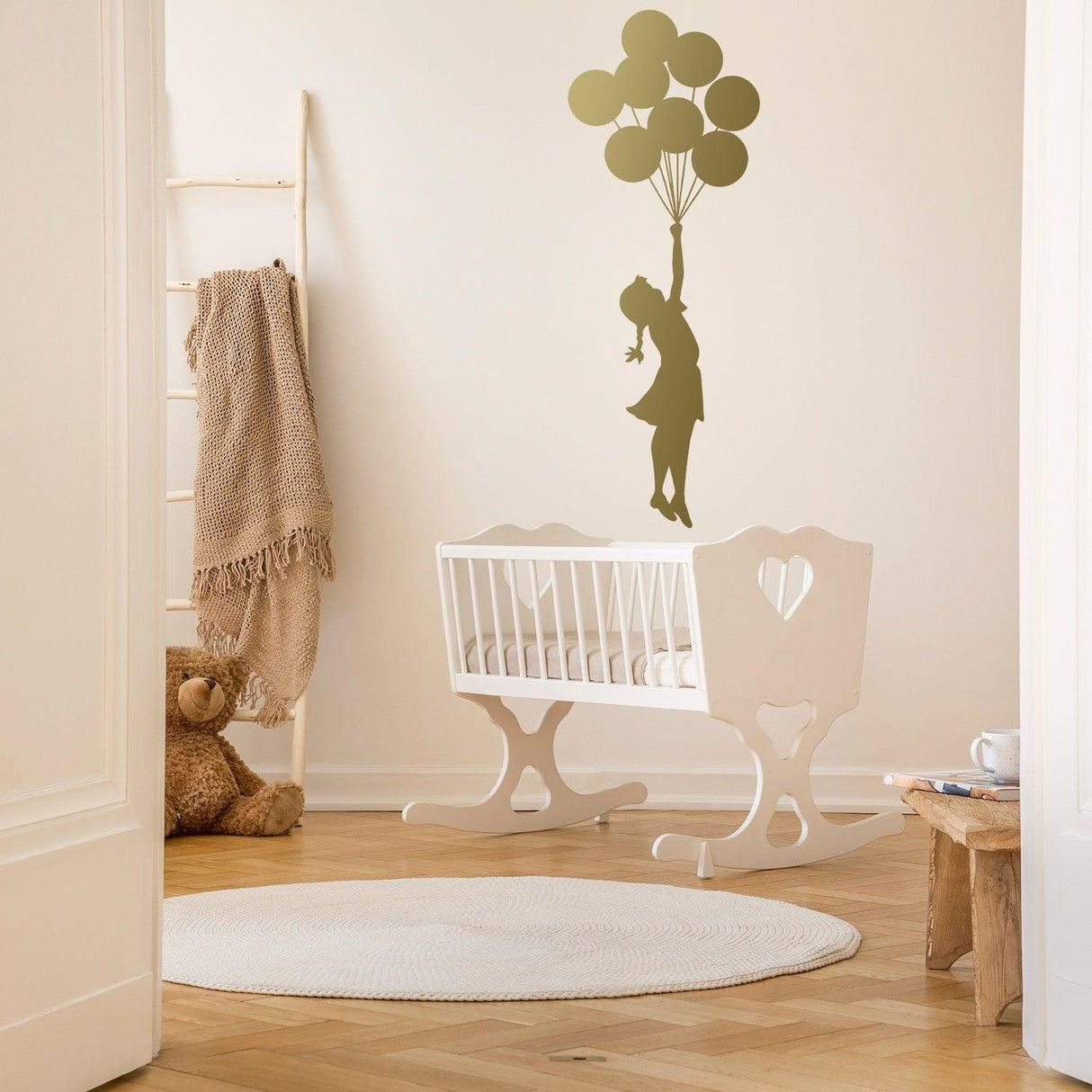 Balloon Girl Banksy wall sticker in a nursery with a crib, cute decor for baby's room.