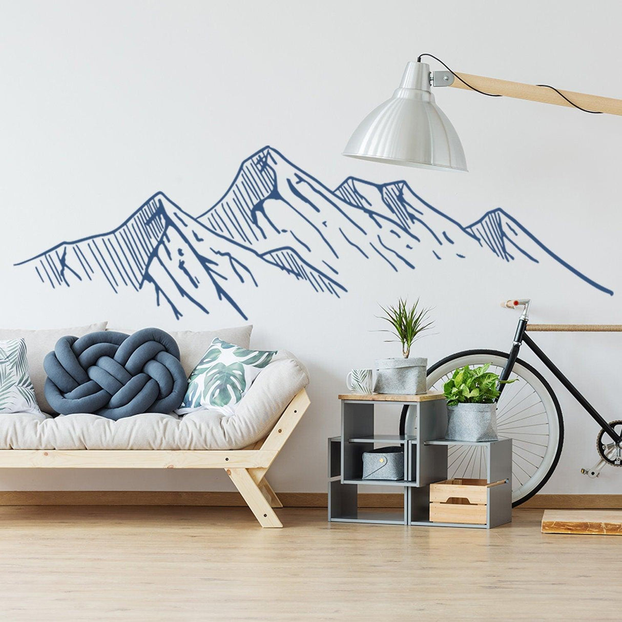 Mountain silhouette wall decal in a modern living room with cozy furniture and a bike.