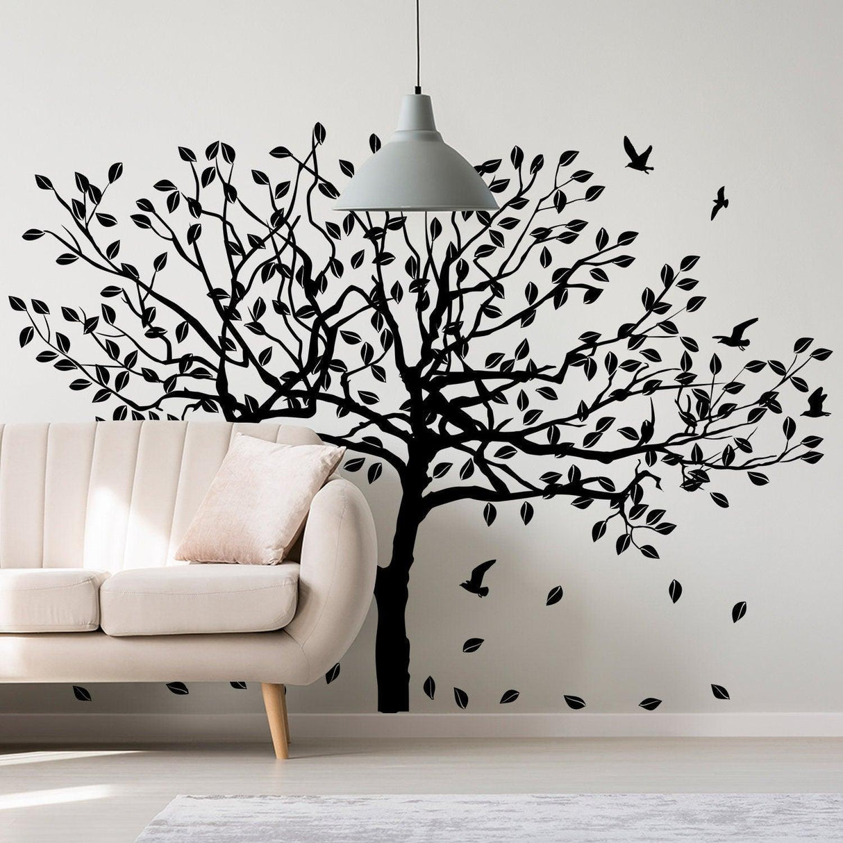 Black birch tree wall decal with birds and leaves in modern living room setting.