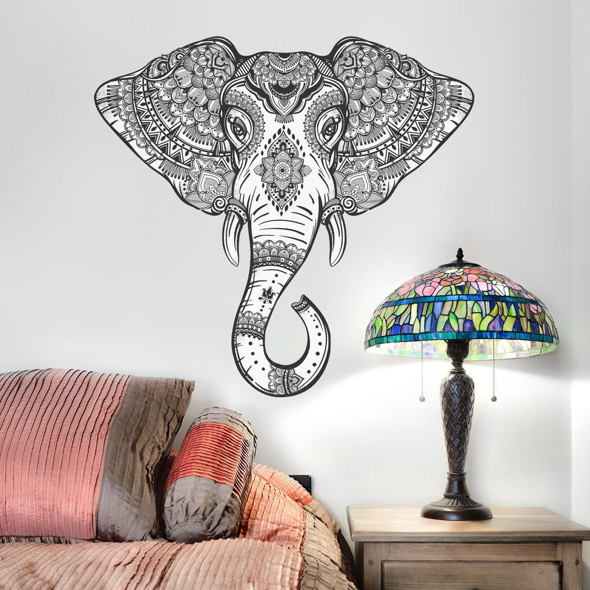 Vinyl tribal elephant wall sticker in black design above a colorful lamp and bedding.