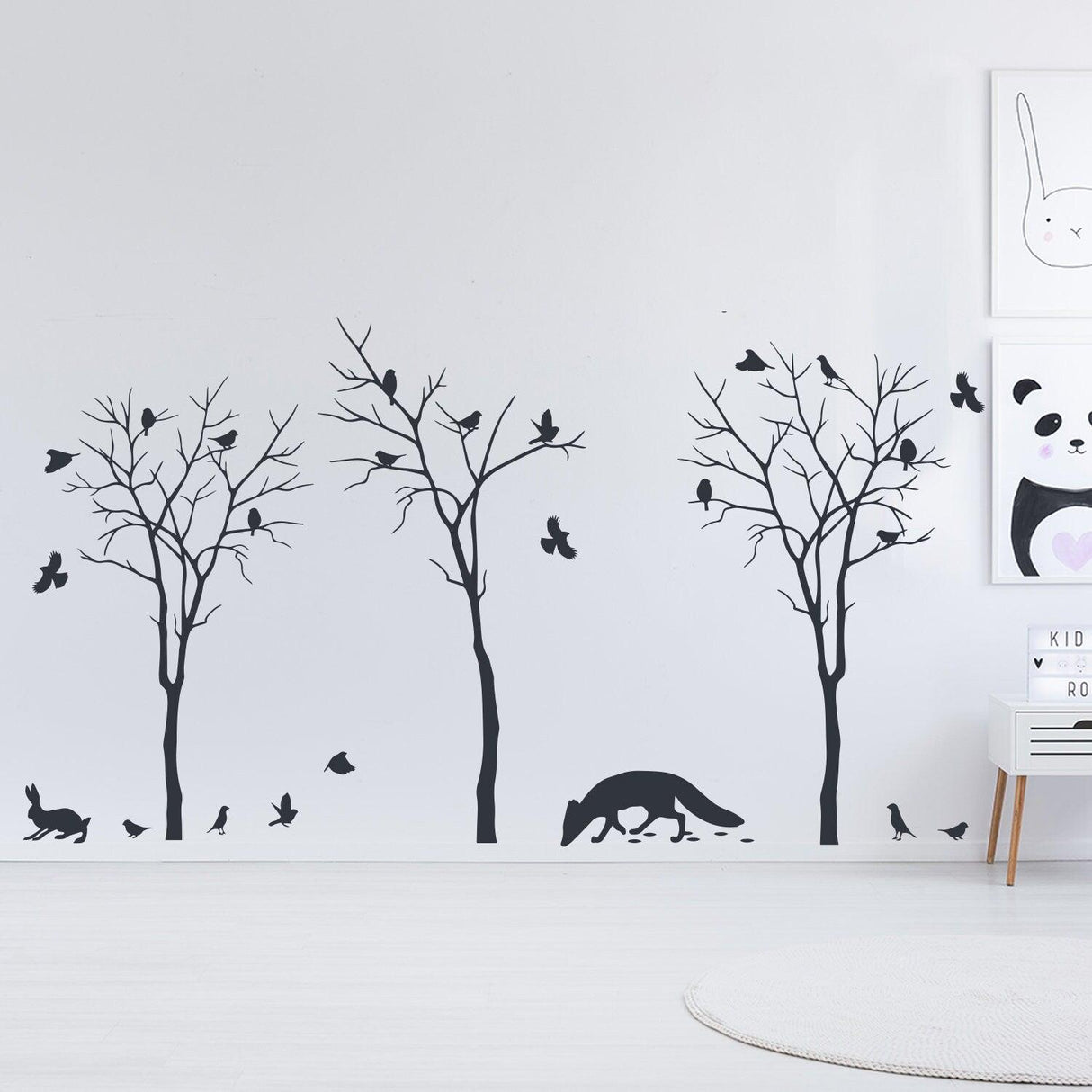 Stylish wall decal featuring black trees, birds, and a fox, perfect for nature-themed decor.