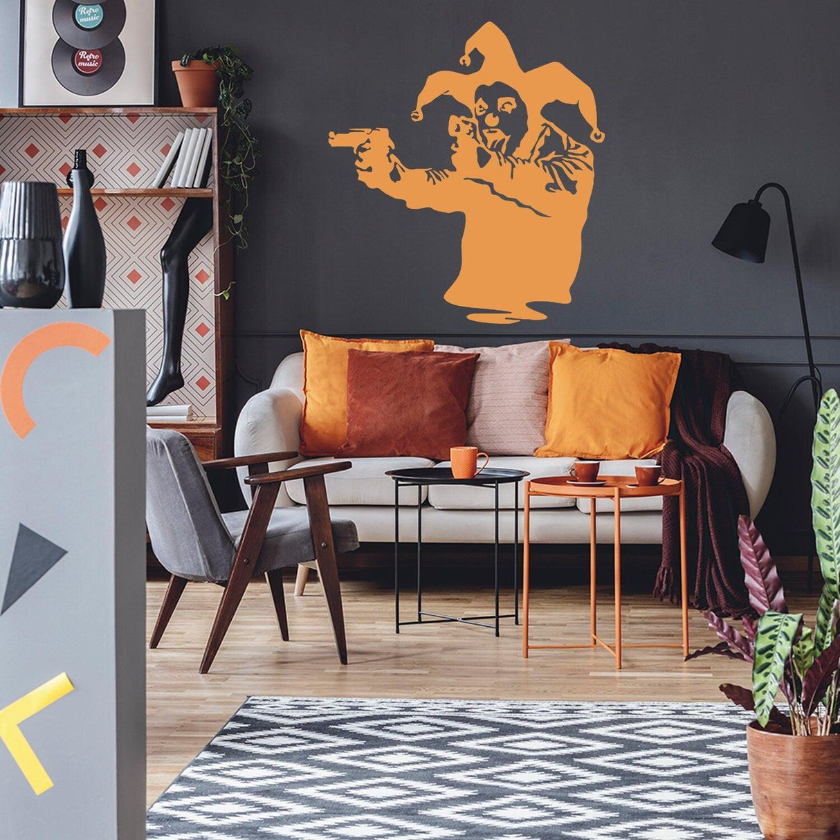Banksy vinyl wall decal of a Joker clown with guns in a stylish modern living room setting.
