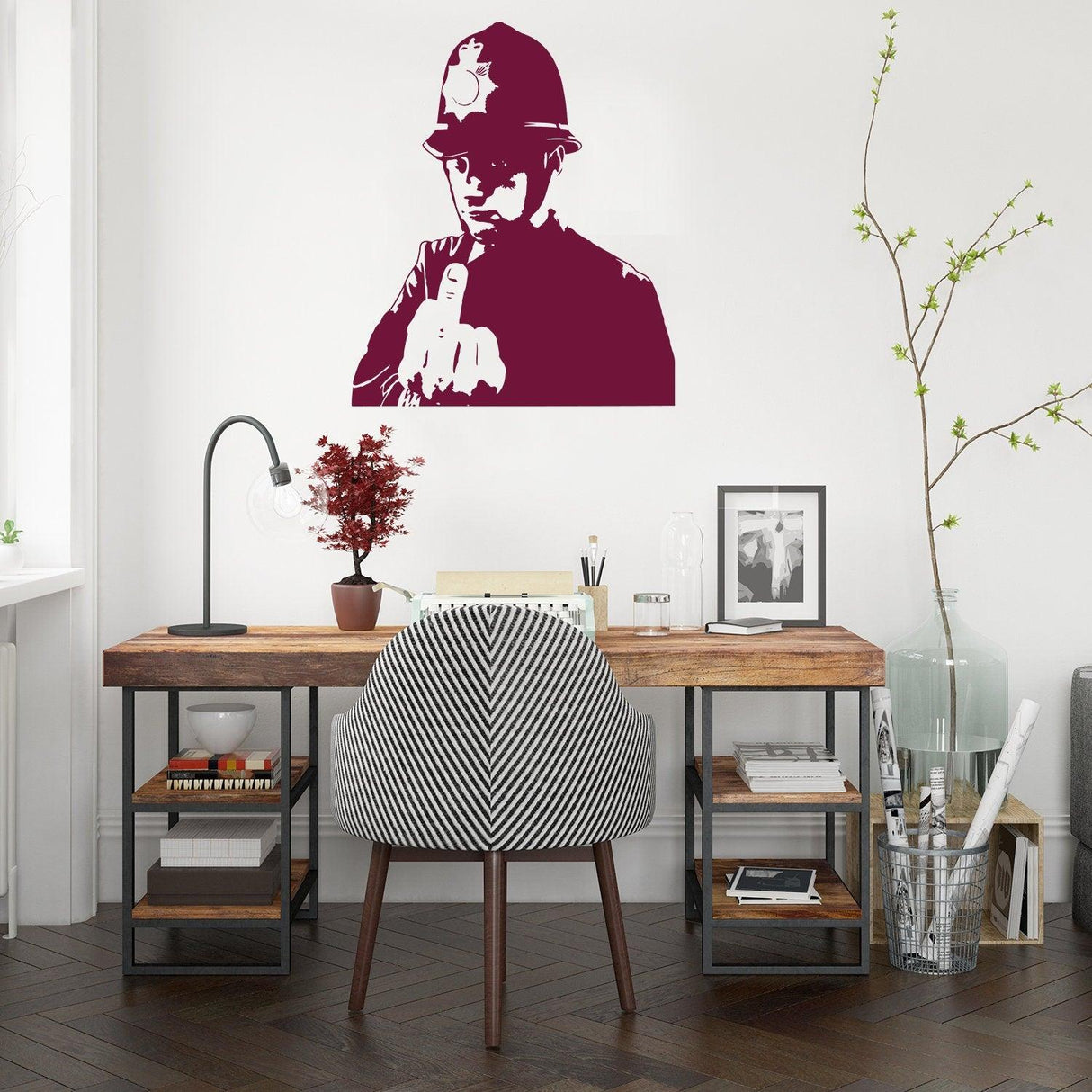 Banksy middle finger art wall decal of a policeman adding a rebellious touch to a modern workspace.