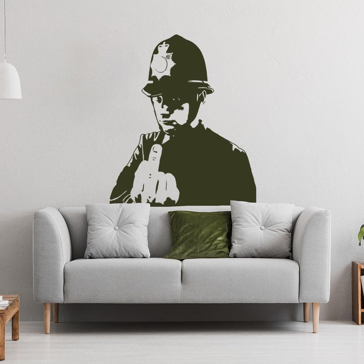 Banksy middle finger art wall decal of a policeman in a modern living room setting.