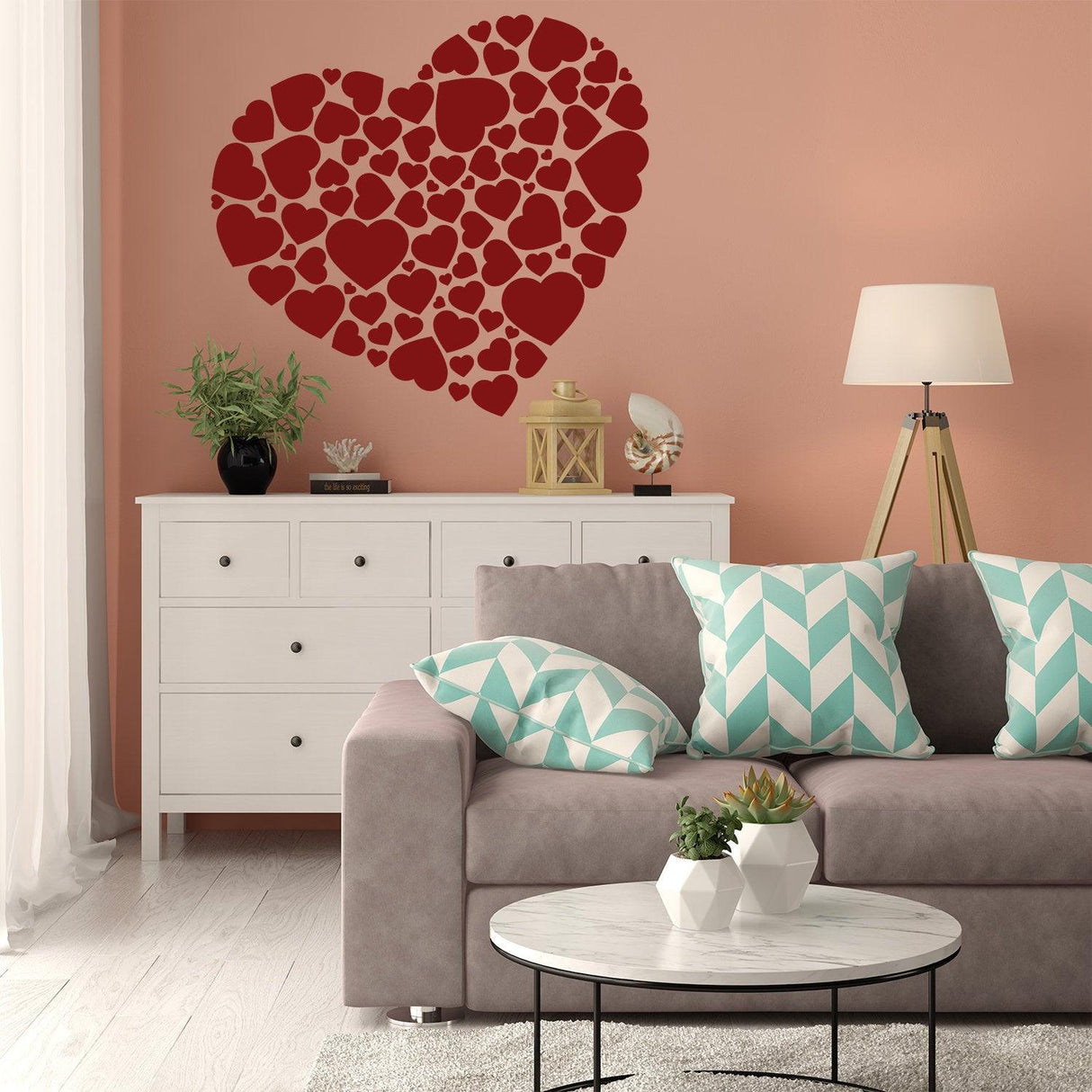 Heart sticker art vinyl love decal on a pink wall above a stylish couch and modern furniture.