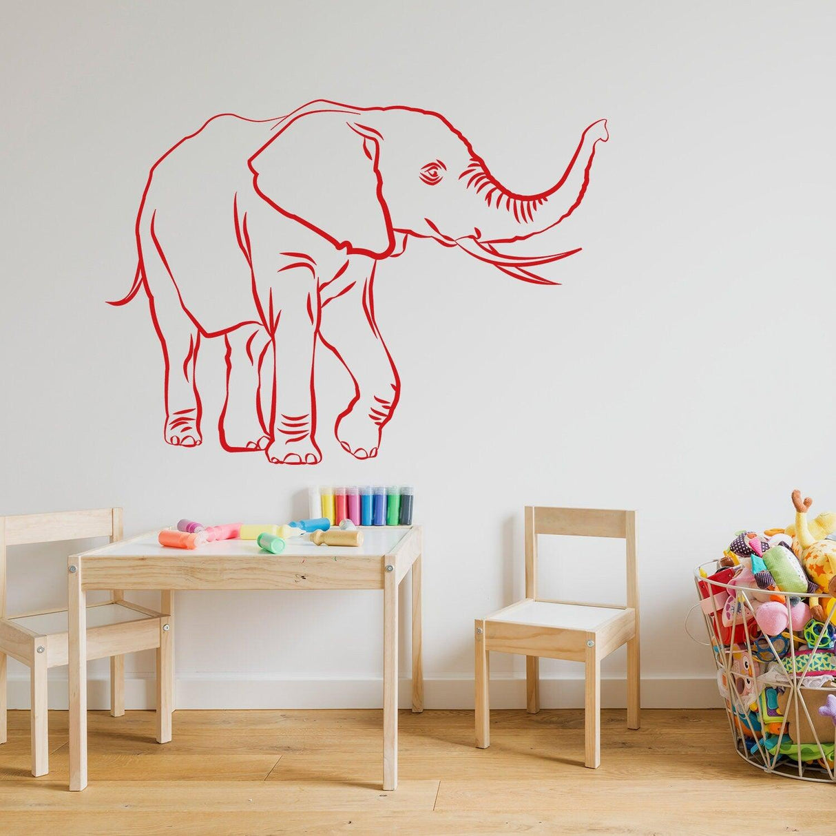 Elephant wall decal sticker in red, adding charm to a child's playroom with colorful toys and furniture.