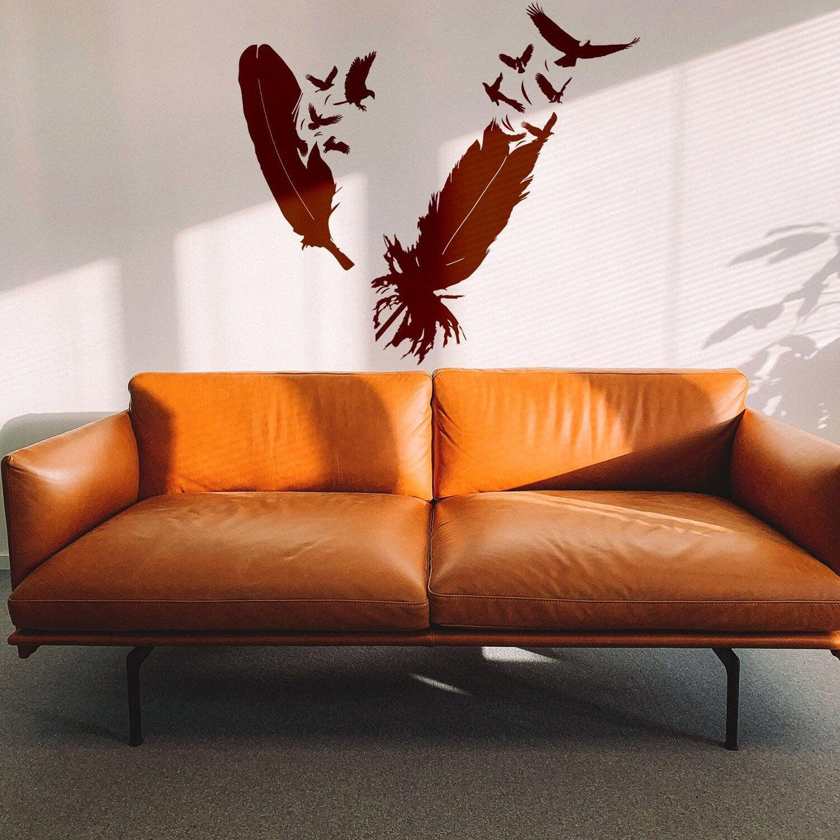 Eagle feather wall vinyl sticker above a stylish brown sofa in bright room decor.