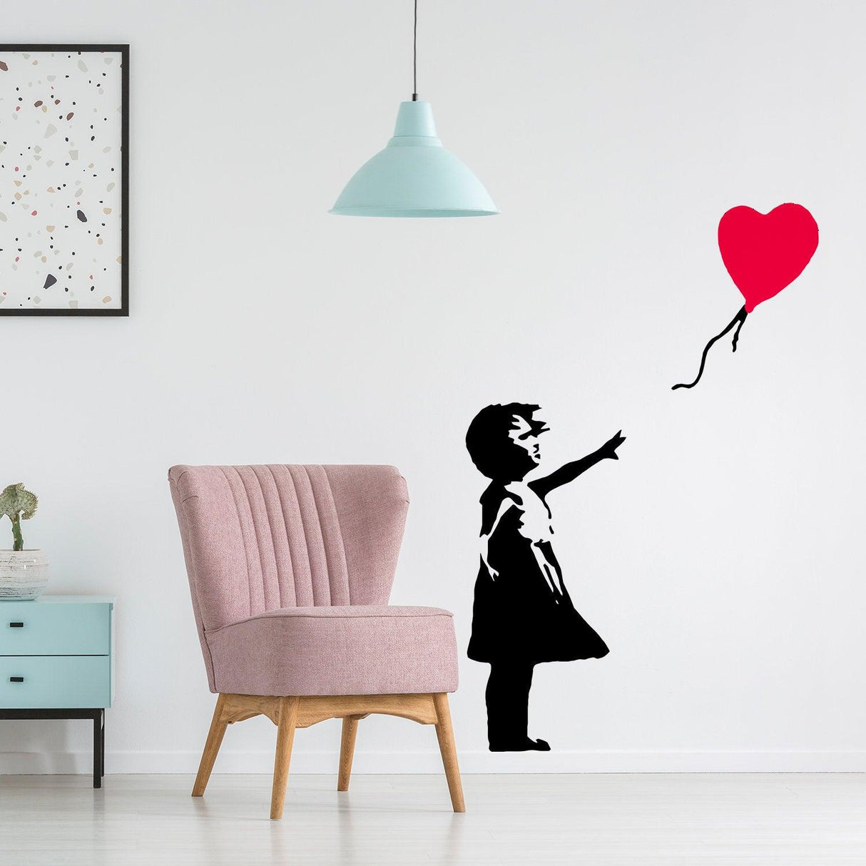 Banksy Girl With Heart Balloon Wall Sticker on a modern wall, featuring a stylish chair and pastel decor.