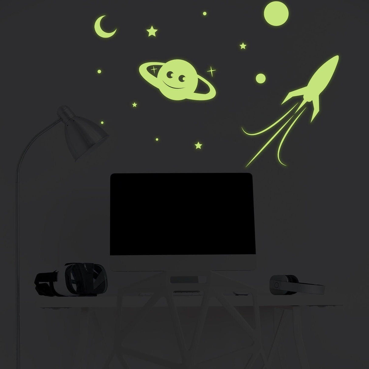 Glowing rocket, planet, moon, and stars wall decal illuminating a dark room, ideal for children's spaces.