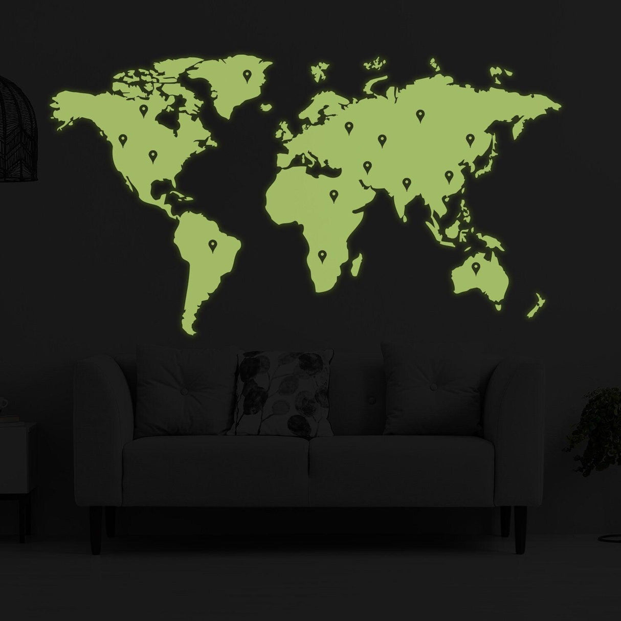 Glow in the dark world map vinyl sticker displayed on a dark wall above a couch, showcasing detailed glow effect.