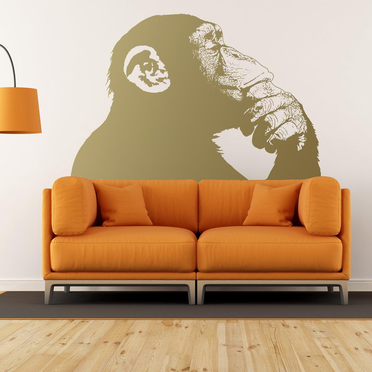 Thinking Monkey wall sticker above an orange couch, featuring Banksy street art design.