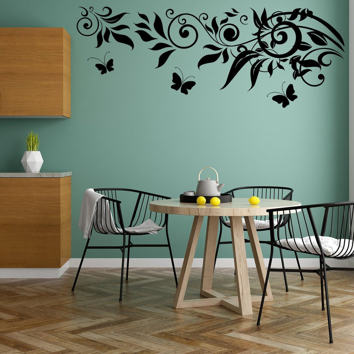 Black butterfly vinyl wall decals over a teal kitchen wall with a wooden table and black chairs.