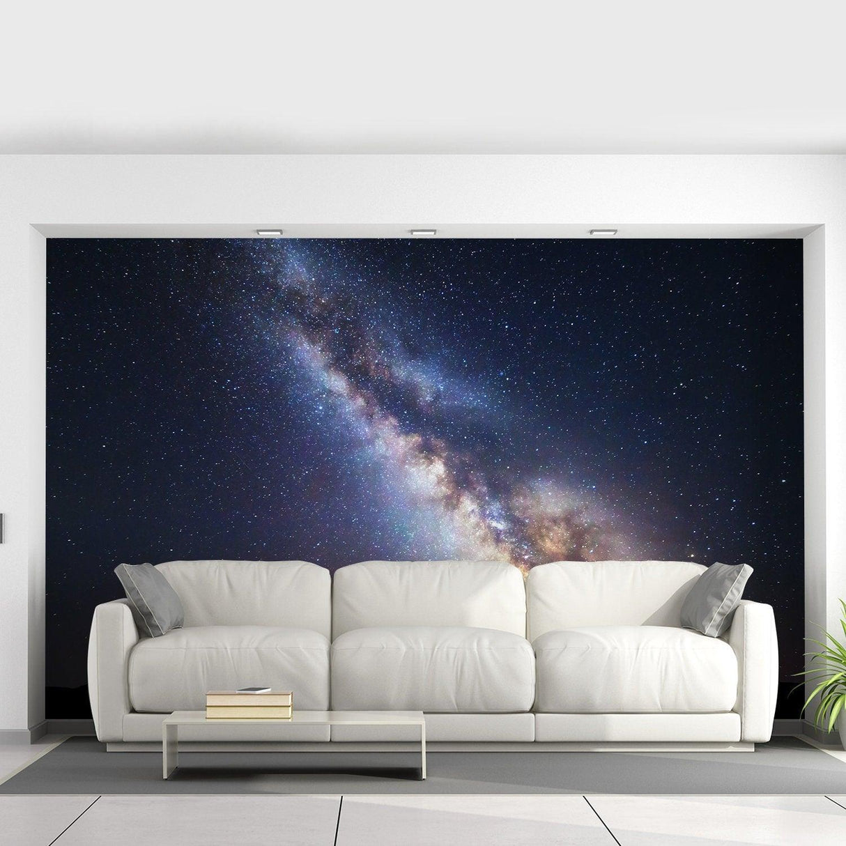 Deep outer space wallpaper mural with galaxy design behind modern white sofa.
