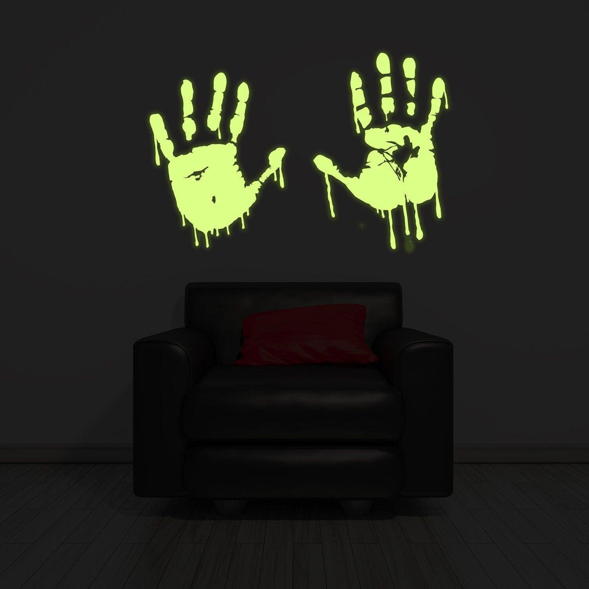 Glow in dark bloody hands vinyl sticker on wall, adding spooky decor to a living room with a black couch.