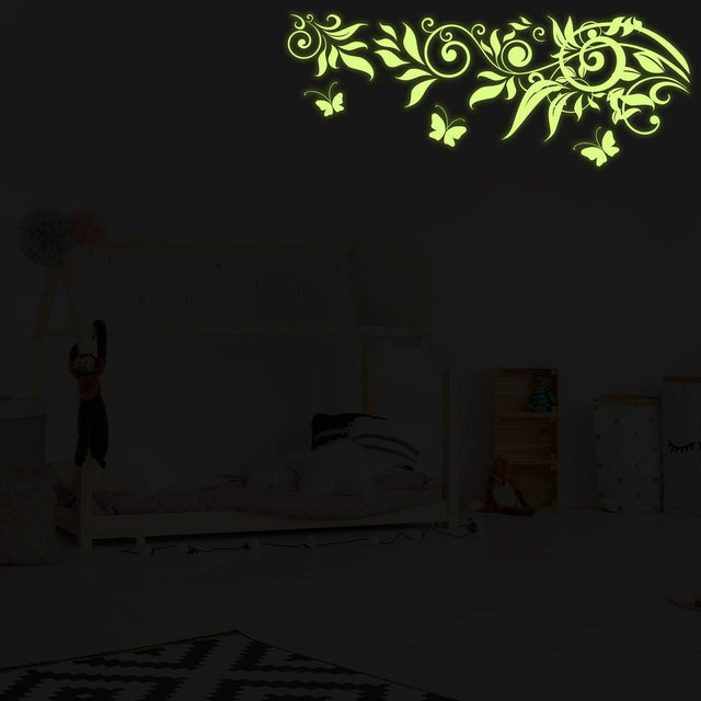 Glow at Night Decal Branch Wall Sticker with glowing flowers and butterflies in a kids' bedroom setting.