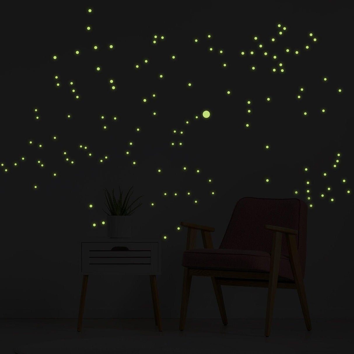 Night glowing star wall stickers illuminating a dark room with a chair and plant, resembling constellations.
